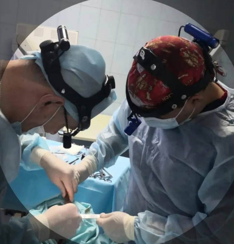 Dos integrantes del equipo quirúrgico trabajando de forma coordinada