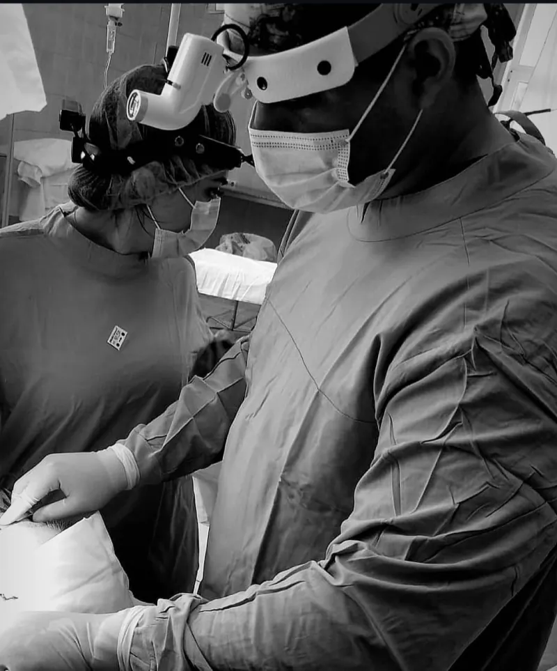 Dr. Jorge Vargas trabajando con su equipo en el quirófano, fotografía en blanco y negro